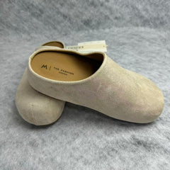 One foot wearing a thick-soled baghdad-style shoe