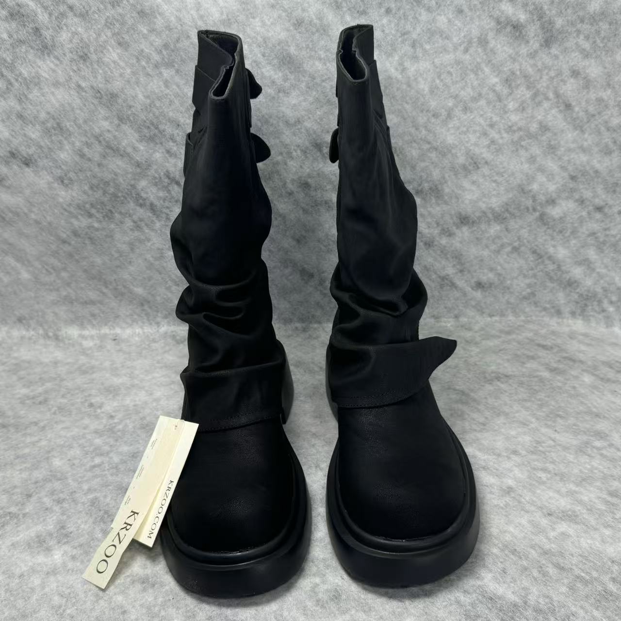 Stacked boots in a creased heap
