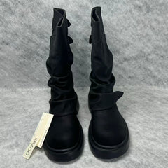 Stacked boots in a creased heap