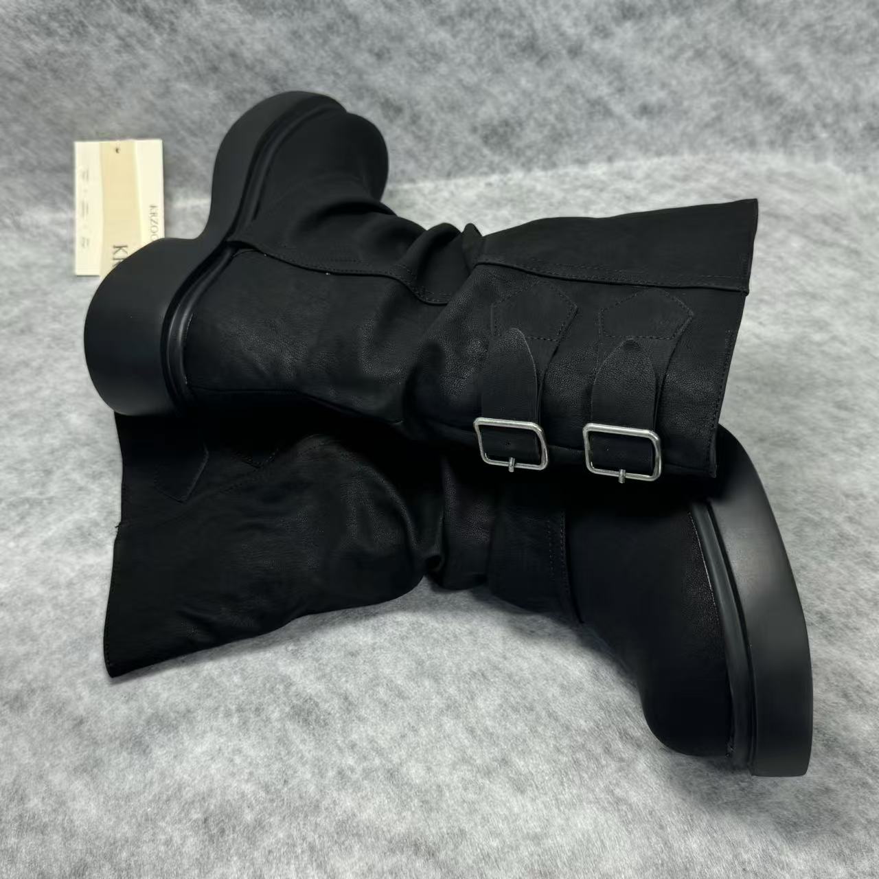 Stacked boots in a creased heap