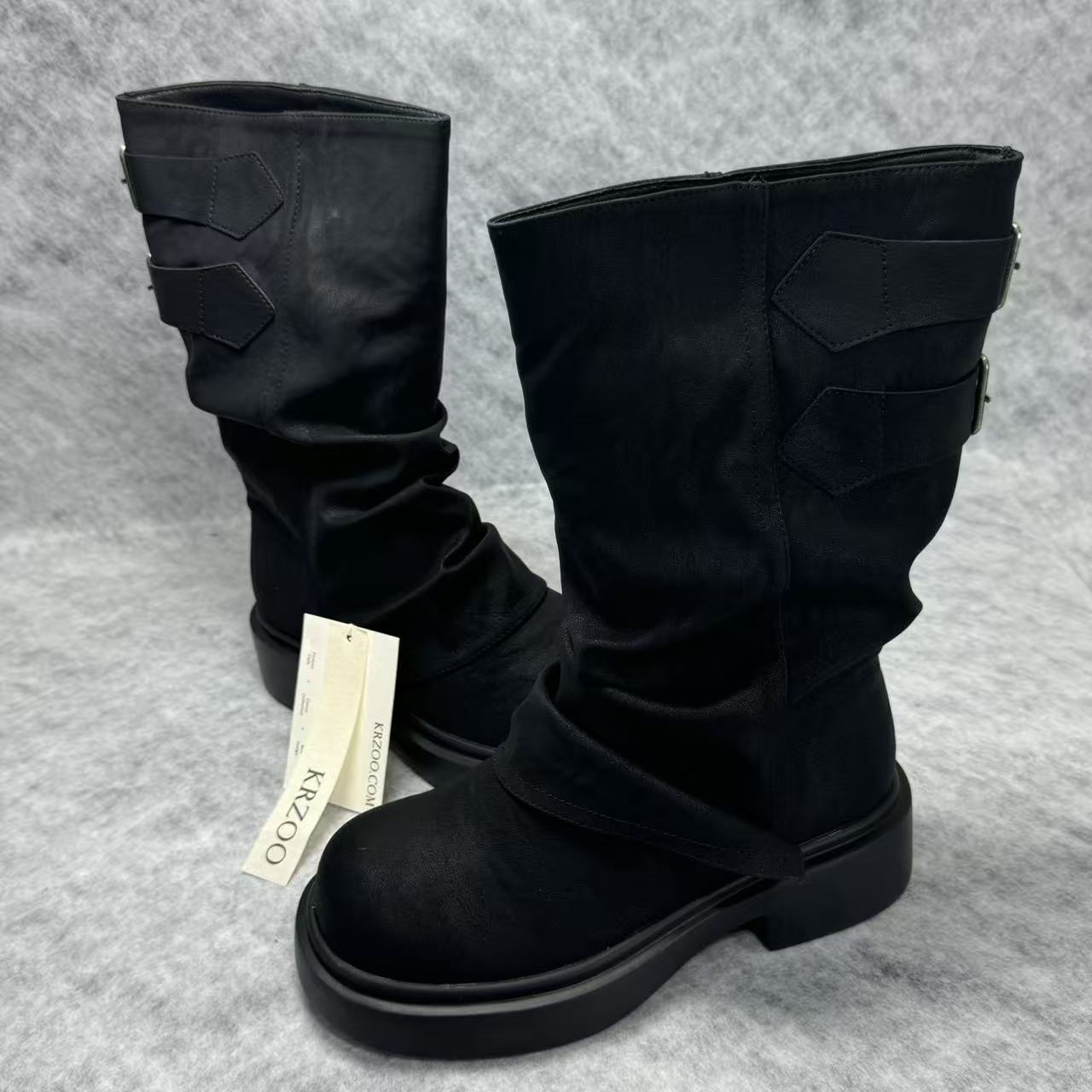 Stacked boots in a creased heap