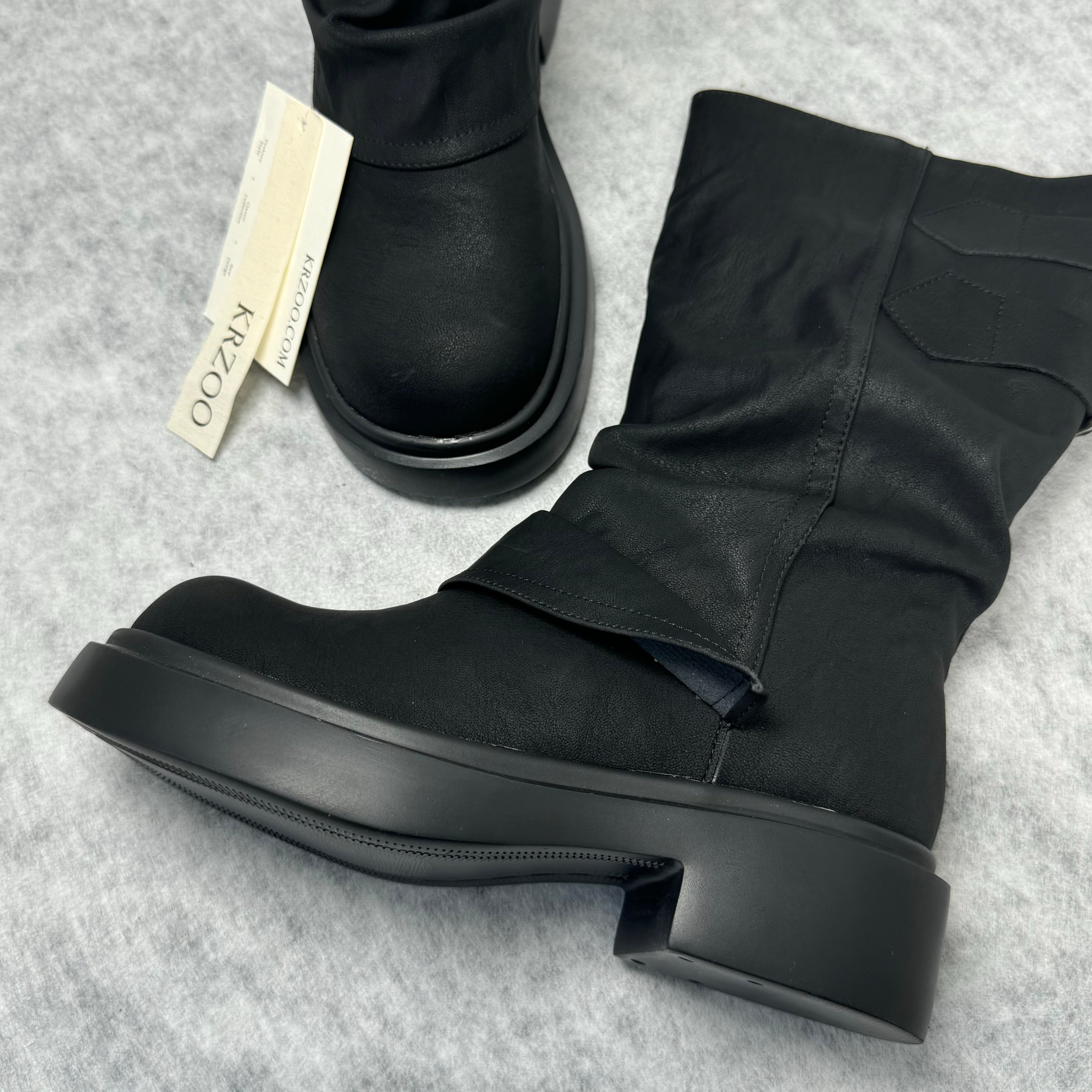 Stacked boots in a creased heap