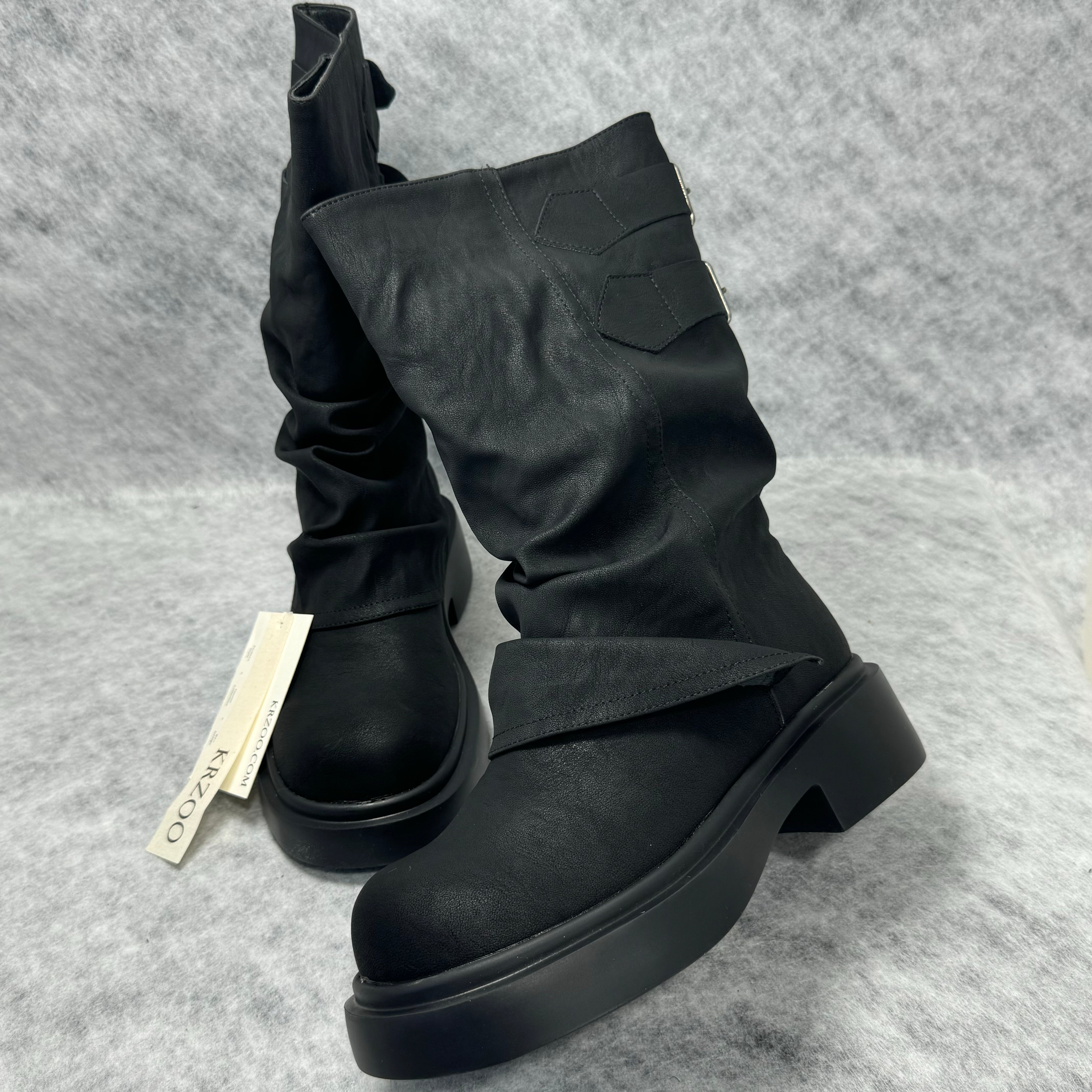 Stacked boots in a creased heap