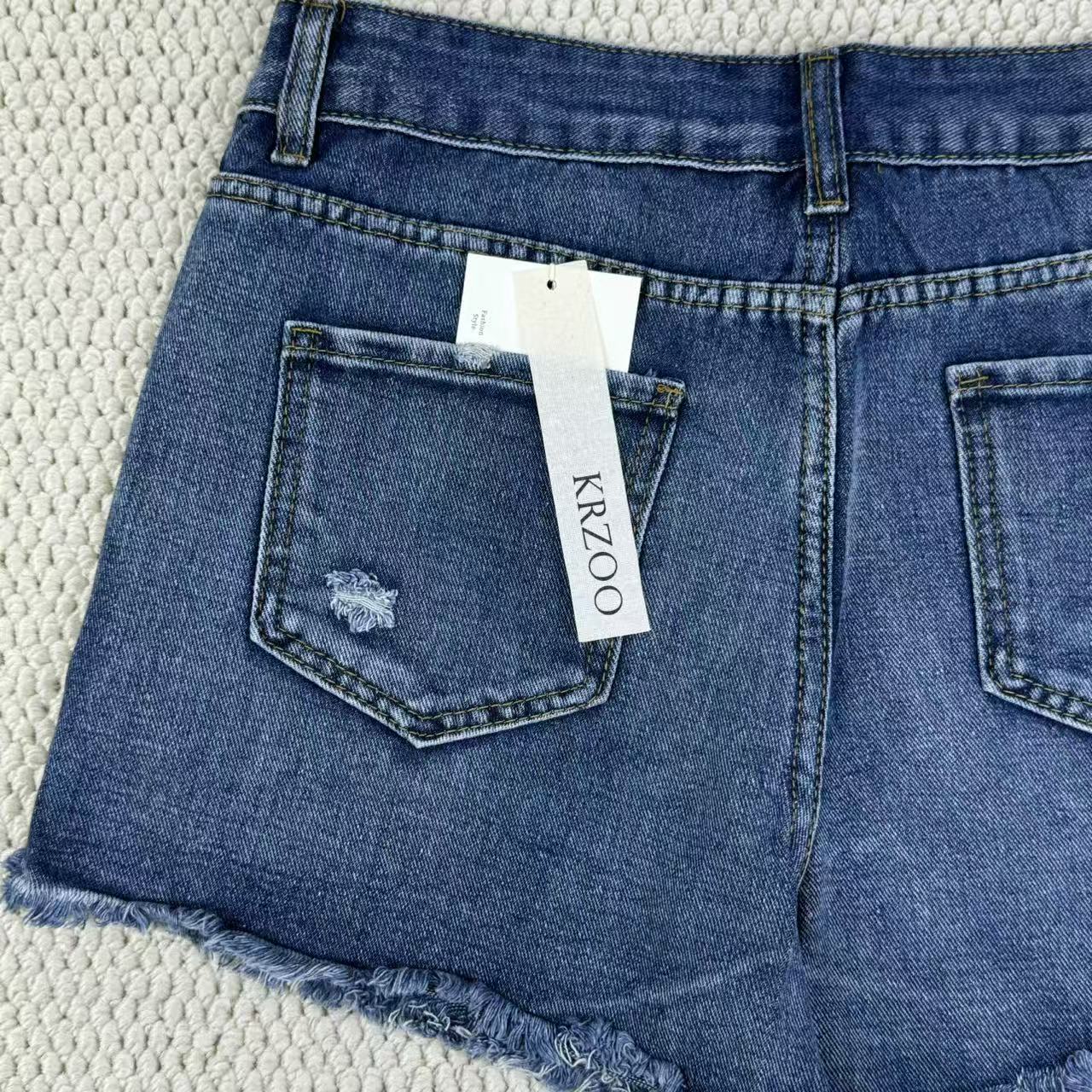 Hole-rimmed fringed denim shorts