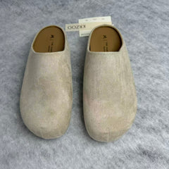 One foot wearing a thick-soled baghdad-style shoe