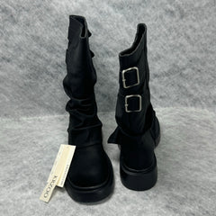Stacked boots in a creased heap