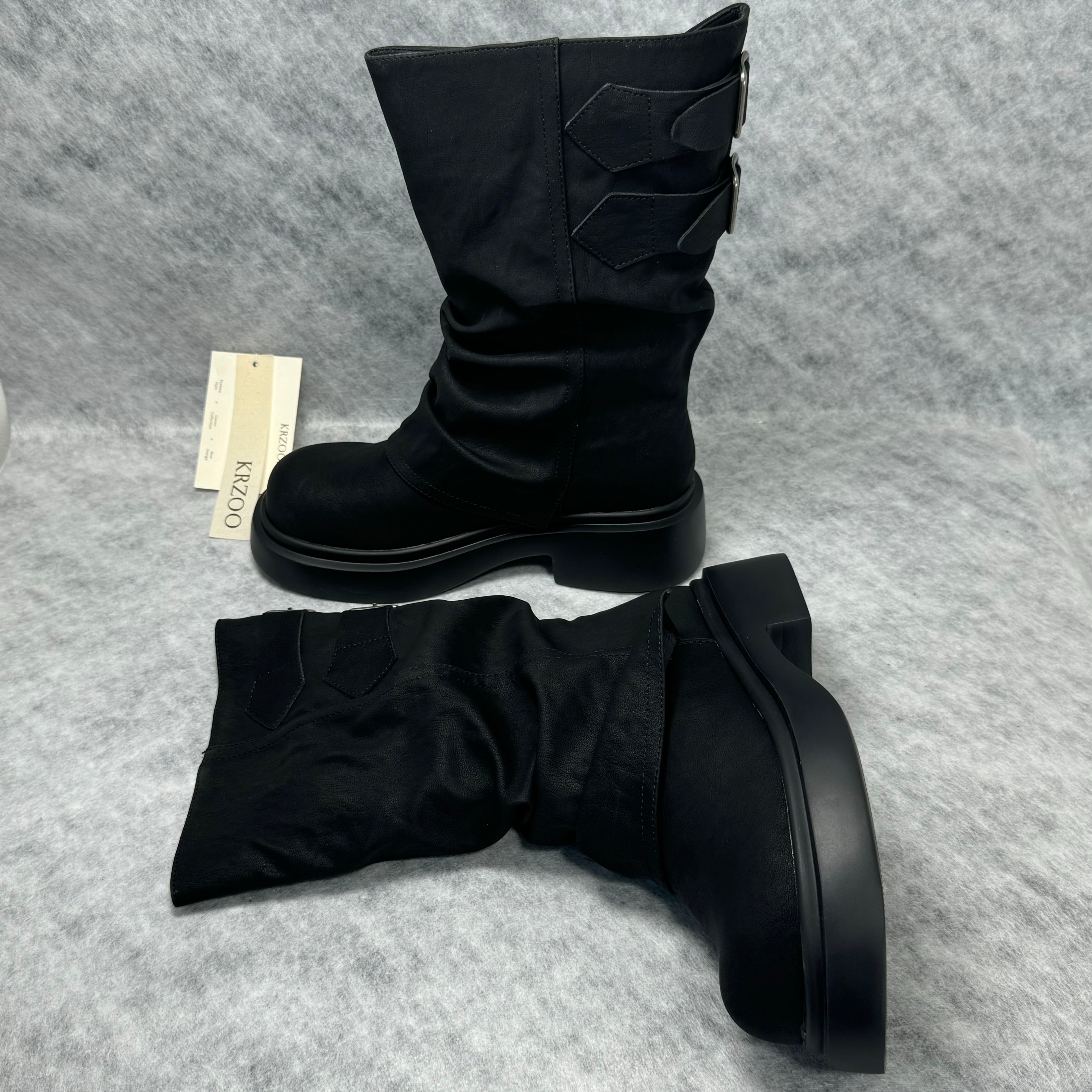 Stacked boots in a creased heap